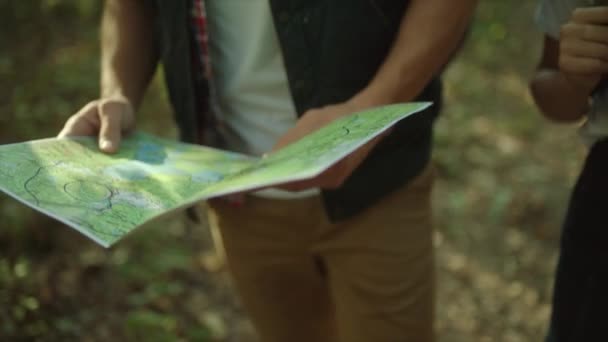 Kaart van de reiziger in de handen van backpacker in het bos — Stockvideo
