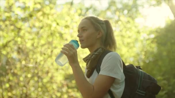 Молодая красивая женщина пьет воду в походах — стоковое видео