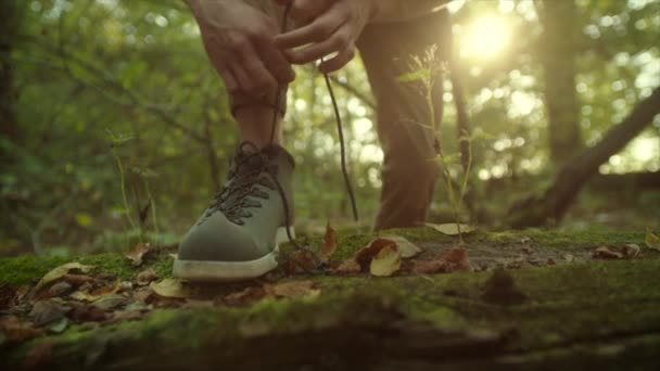 Cierre de cordones de corbata en botas de trekking durante el senderismo al atardecer — Vídeo de stock