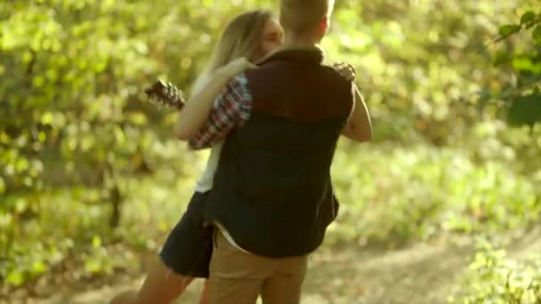 Hermosa joven pareja besándose en caminar en el bosque — Vídeos de Stock
