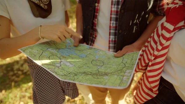 Mochileros discutiendo el camino en el mapa del viajero en la caminata —  Fotos de Stock