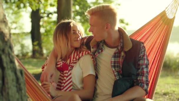 Feliz pareja joven besándose en las vacaciones de verano en la puesta del sol — Vídeo de stock