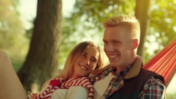 Romantisches junges Paar küsst sich in Hängematte draußen — Stockvideo