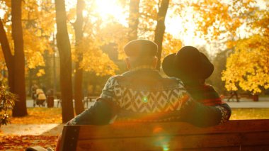 Üst düzey çift günbatımı sonbahar parkta bankta zevk