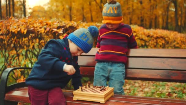 Jongetjes zijn Schaken in de herfst park — Stockvideo