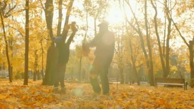 Dede ve torunu düşen yapraklar savurma ve sonbahar parkta oynarken