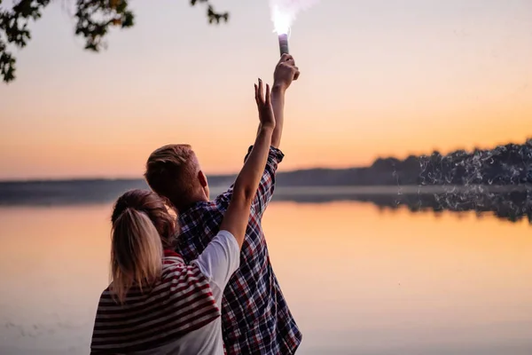 Backshot de adolescentes con fuego chispeante al atardecer —  Fotos de Stock