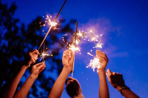 Gece gökyüzü üzerinde elinde maytap kadar kapatın