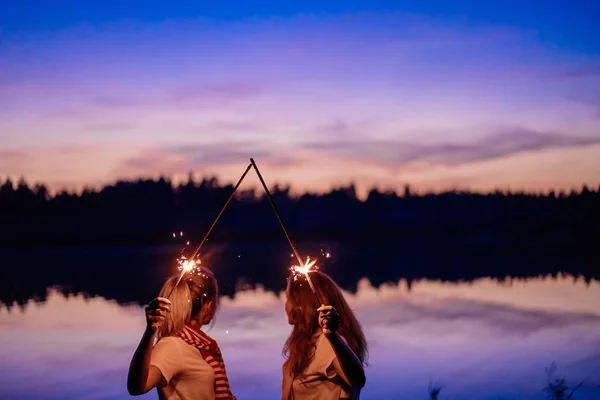 Amigos comemorando a festa noturna com brilhos e confetes — Fotografia de Stock