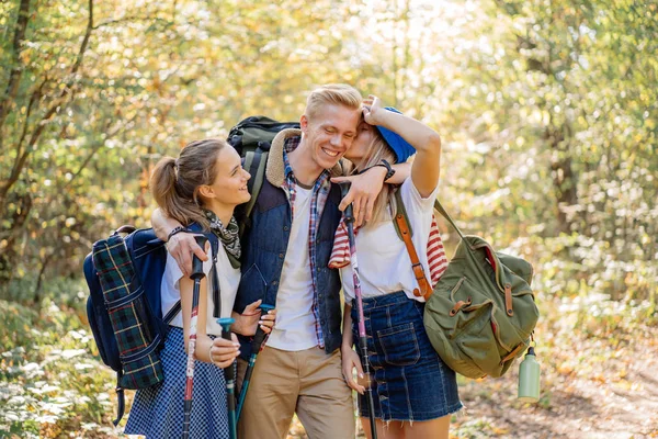 Grupo de felices mejores amigos disfrutando de senderismo junto con enormes mochilas y palos nórdicos —  Fotos de Stock