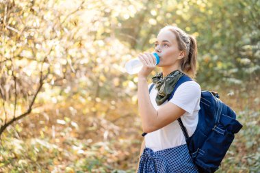 Genç güzel kadın içme suyu spor şişe üzerinde yürüyüş