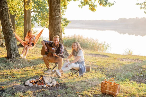 Gitar çalmak ve hiking göl piknik ateşin ortasına, zevk arkadaşlarım