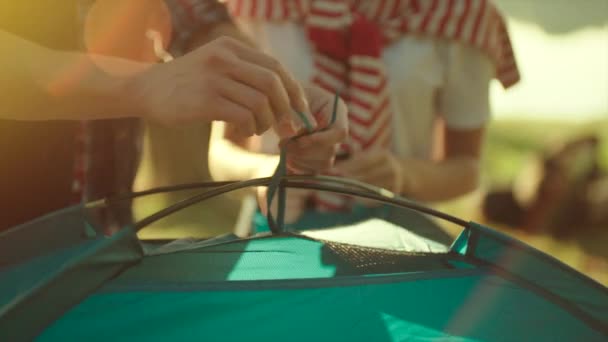 Amici che piantano una tenda insieme durante un'escursione al tramonto — Video Stock