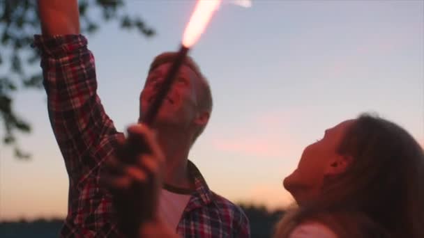 Friends celebrating with sparkles in their hands at sunset — Stock Video
