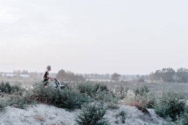 Genç kadın onun motosiklet üzerinde günbatımında binme