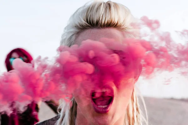 Close up retrato feminino gritando em fumaça rosa — Fotografia de Stock