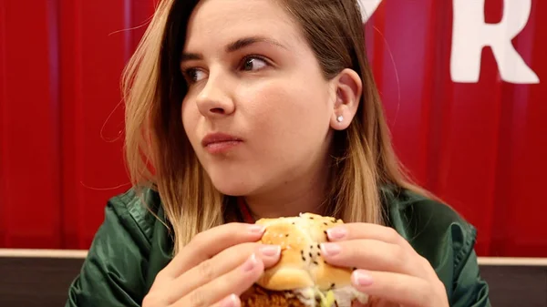 Joven hermosa mujer con sabrosa hamburguesa en sus manos —  Fotos de Stock