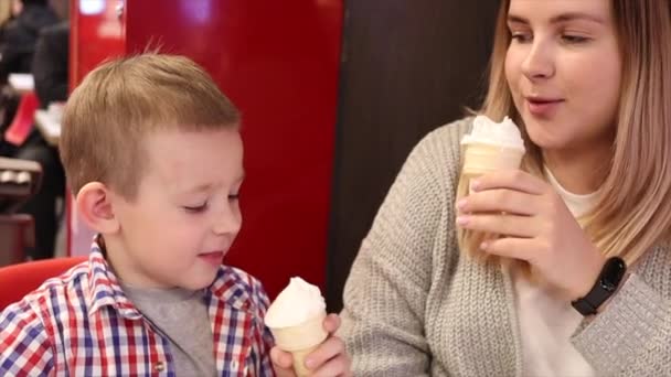 Niño y su mamá comiendo helado en la cafetería — Vídeo de stock