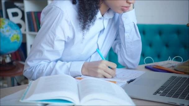 Close up nenhuma cara estudante do sexo feminino fazendo uma nota enquanto se prepara para o exame na biblioteca da universidade — Vídeo de Stock