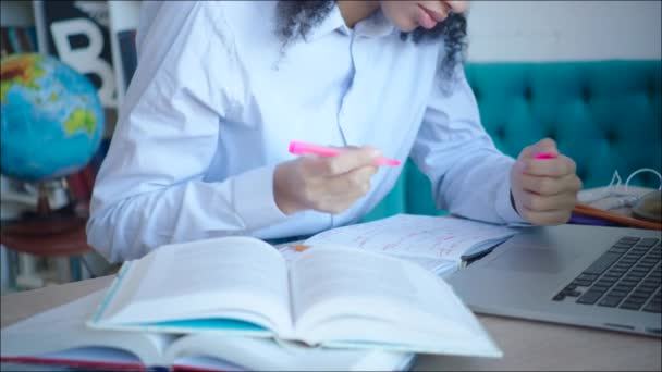 Primer plano africano amerciana estudiante haciendo marcas en los libros de texto mientras se prepara para el examen — Vídeos de Stock