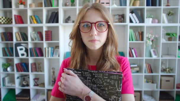 Porträtt av rött hår vacker Skolflicka bär glasögon med handledning i hennes händer — Stockvideo