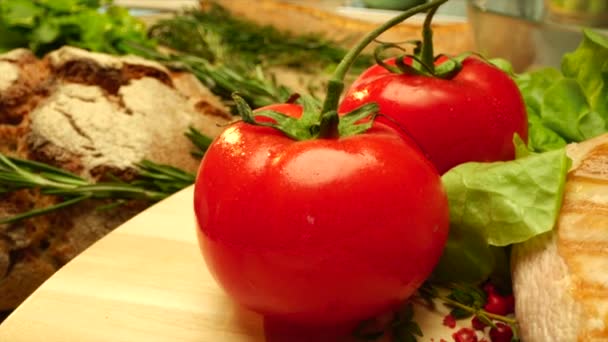 Закройте соленые куриные грудки со свежими помидорами за кухонным столом — стоковое видео
