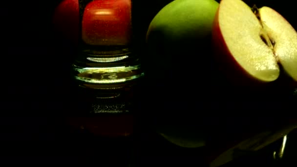 Pouring cider into glasses and ripe apples on the black background — Stock Video