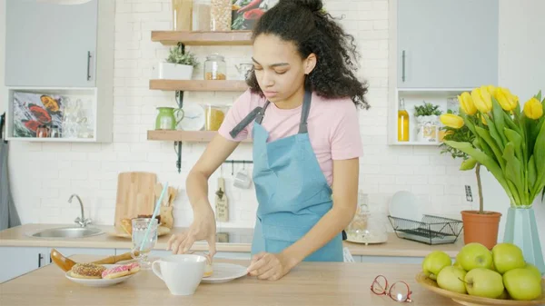 Mujer afroamericana joven está haciendo el desayuno en la cocina Imagen De Stock