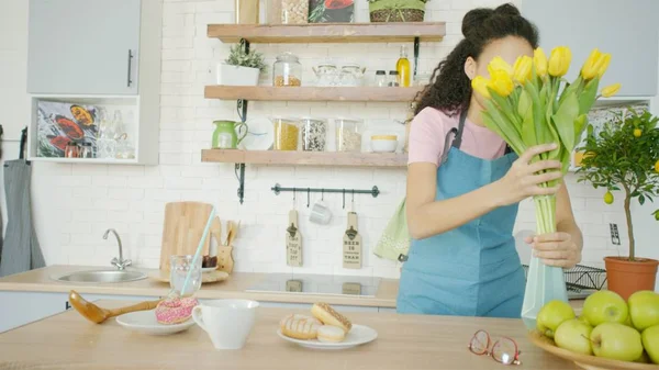 Młoda kobieta wkłada kwiaty do wazonu na stół. Zdjęcia Stockowe bez tantiem