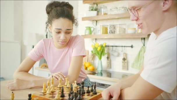 Young african american woman is playing chess with blonde man — 비디오