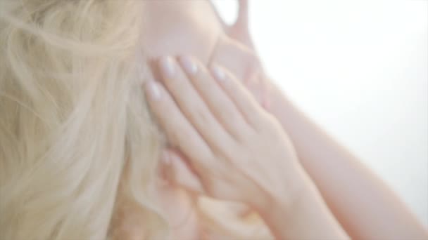 Сексуальная красивая блондинка улыбается чувственным взглядом на белом фоне — стоковое видео