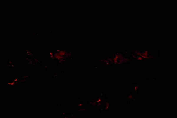 たき火の灰をくすぶっています 白熱灯のオレンジと赤の残り火のテクスチャです 暗い背景 レンガのバーベキューで薪と炎 外の食事を調理するための場所 — ストック写真