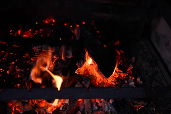 Asfixiantes cenizas de una hoguera. Llama de fuego en una barbacoa de ladrillo —  Fotos de Stock