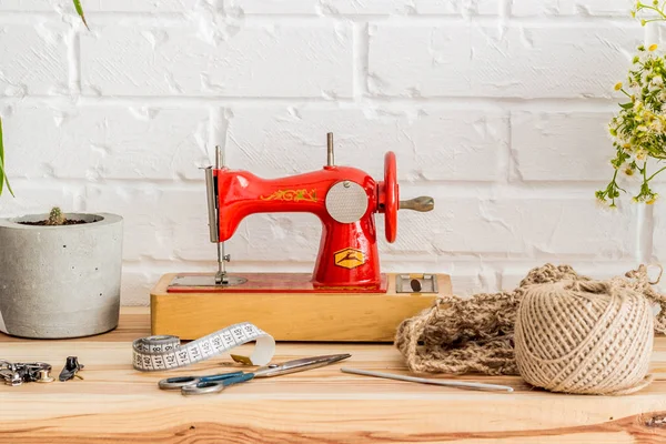 木製のテーブルの上に赤いミシン。縫製業界。Diy — ストック写真