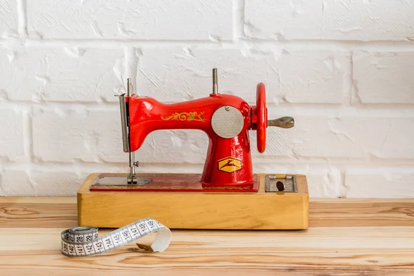 Red sewing machine on a wooden table. Sewing industry. Diy — Stock Photo, Image