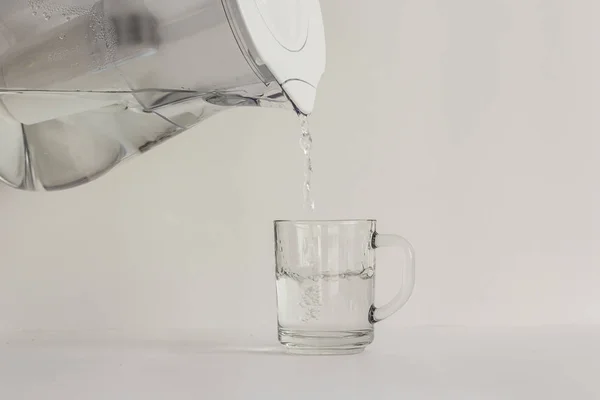 Água purificada em um jarro com um filtro e um vidro transparente — Fotografia de Stock