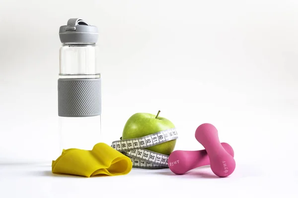 Jablko s měřicí páskou, fitness elastickým pásem, vodní lahví a činky — Stock fotografie