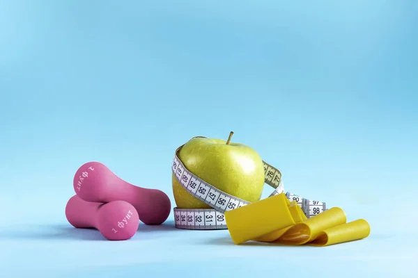 Äpple med måttband, fitness elastiskt band och hantlar — Stockfoto
