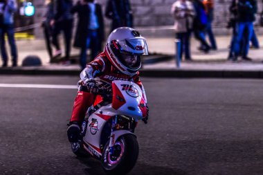 Sokakta bir çocuk oyuncak motosiklet sürmek