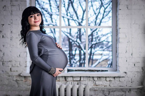 Femme Enceinte Tient Fenêtre Dans Robe Grise Paysage Hiver Extérieur — Photo