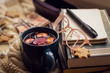 Nesne fotoğraf. Pencere kenarında kitap, Not defteri, gözlük çantası, tanımlama bilgileri, termoz ve kupa mulled şarap ile yalan.