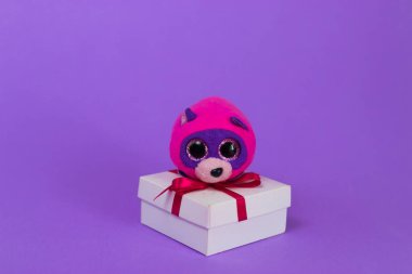 Oyuncak karikatür fare bir beyaz hediye kutusu üzerinde oturur.