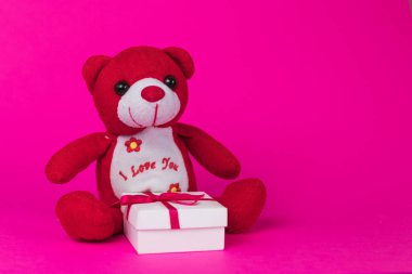 Oyuncak pembe bir arka plan üzerinde beyaz hediye kutuları ile Noel Baba çizgi film.