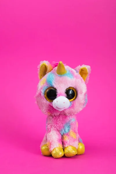 Toy Pink Unicorn sits on a pink background.