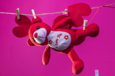 Oyuncak oyuncak ayı arka plan beyaz bulutlar üzerinde ip clothespins uzaklaştırıldın