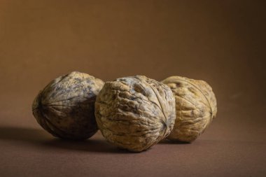 koyu kahverengi zemin üzerinde üç ceviz ceviz.