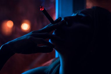 bir sigara gece ışık, veznedeki kıza siluet.