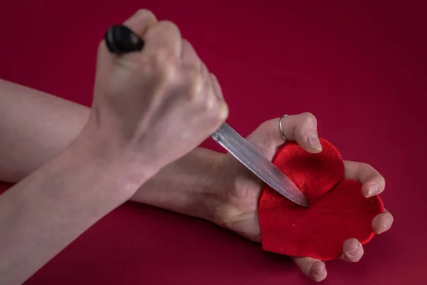 Stab the knife into the red heart in concept meaning Destroy my heart.