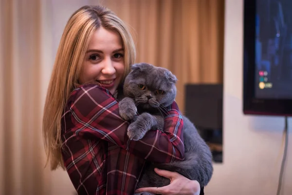 Beautiful hot girl hugs cute british cat.
