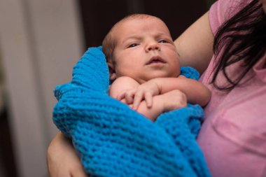 Annem onun yeni doğan bebeği kollarında saklar.